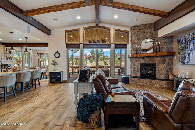 2737 Skyhawk Dr, Overgaard, AZ 85933 - living area with light wood finished floors, visible vents, a stone fireplace, and beamed ceiling