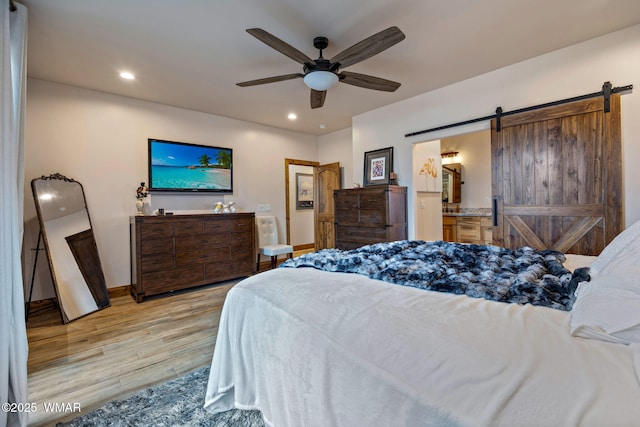 2737 Skyhawk Dr, Overgaard, AZ 85933 - bedroom featuring recessed lighting, ensuite bath, a barn door, ceiling fan, and light wood finished floors