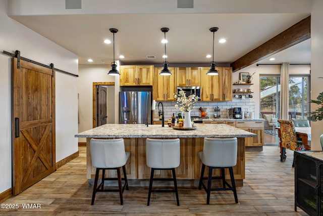 2737 Skyhawk Dr, Overgaard, AZ 85933 - kitchen featuring tasteful backsplash, a barn door, a center island with sink, stainless steel appliances, and wood finished floors