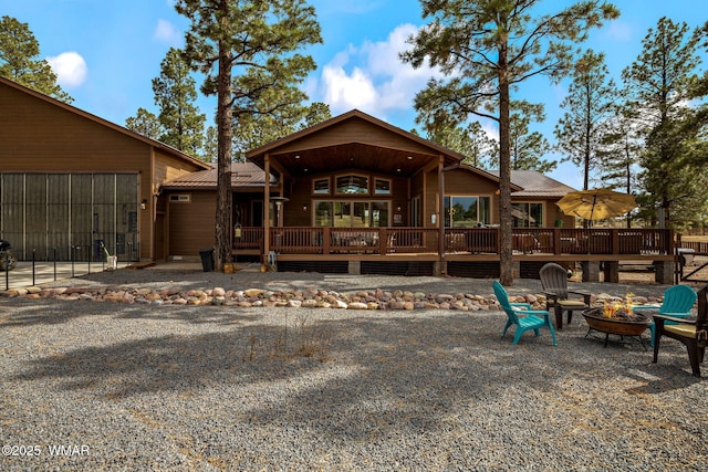 2737 Skyhawk Dr, Overgaard, AZ 85933 - rear view of property featuring a wooden deck, metal roof, and a fire pit