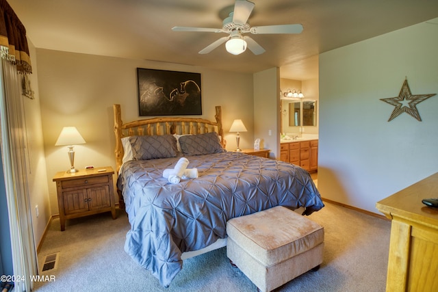 bedroom with carpet floors, visible vents, ensuite bathroom, a ceiling fan, and baseboards