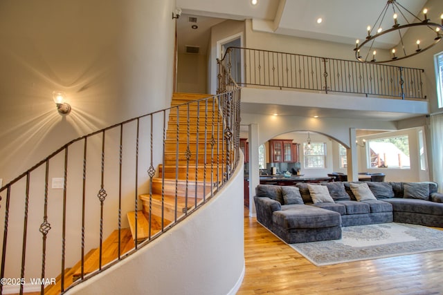 4701 S Manzanita Way, Show Low, AZ 85901 - living area with a chandelier, wood finished floors, stairway, a towering ceiling, and arched walkways