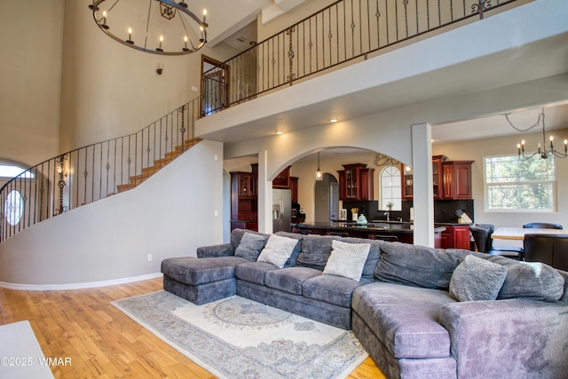 4701 S Manzanita Way, Show Low, AZ 85901 - living area with a chandelier, light wood finished floors, arched walkways, a high ceiling, and stairway