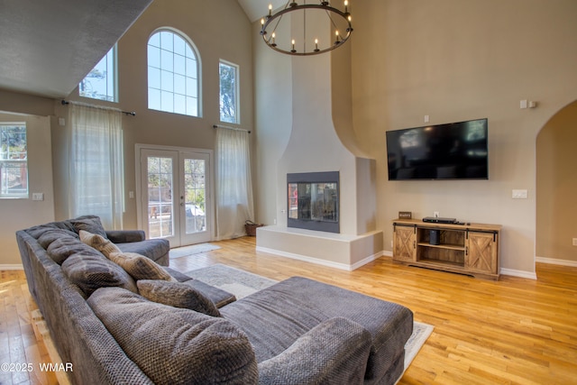 4701 S Manzanita Way, Show Low, AZ 85901 - living room with light wood finished floors, arched walkways, a chandelier, healthy amount of natural light, and a high ceiling