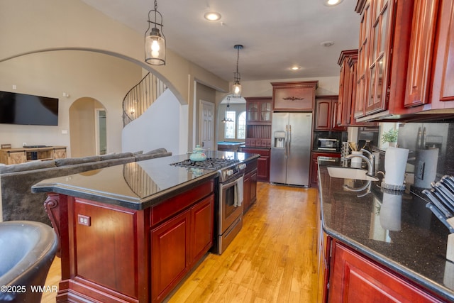 4701 S Manzanita Way, Show Low, AZ 85901 - kitchen with stainless steel appliances, dark brown cabinets, arched walkways, a sink, and glass insert cabinets