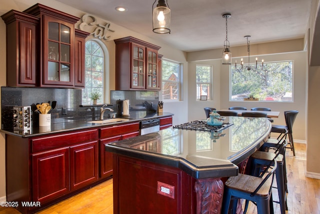 4701 S Manzanita Way, Show Low, AZ 85901 - kitchen with dark brown cabinets, a sink, a chandelier, light wood-style floors, and tasteful backsplash