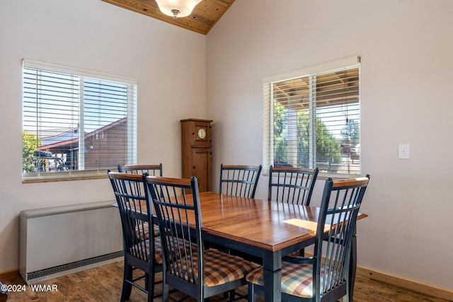 dining area featuring vaulted ceiling, baseboards, and wood finished floors