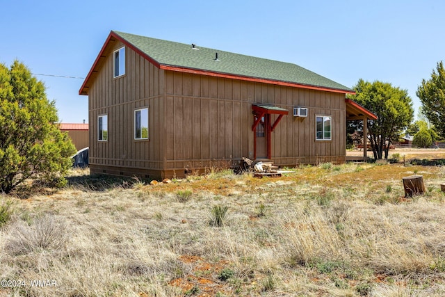 view of side of property with roof with shingles