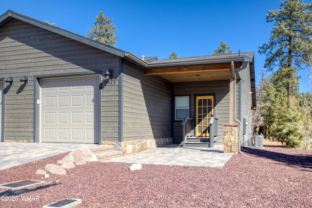 ranch-style home with an attached garage and central air condition unit