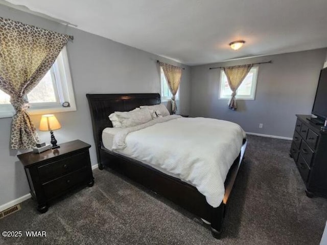 bedroom featuring visible vents, dark carpet, and baseboards