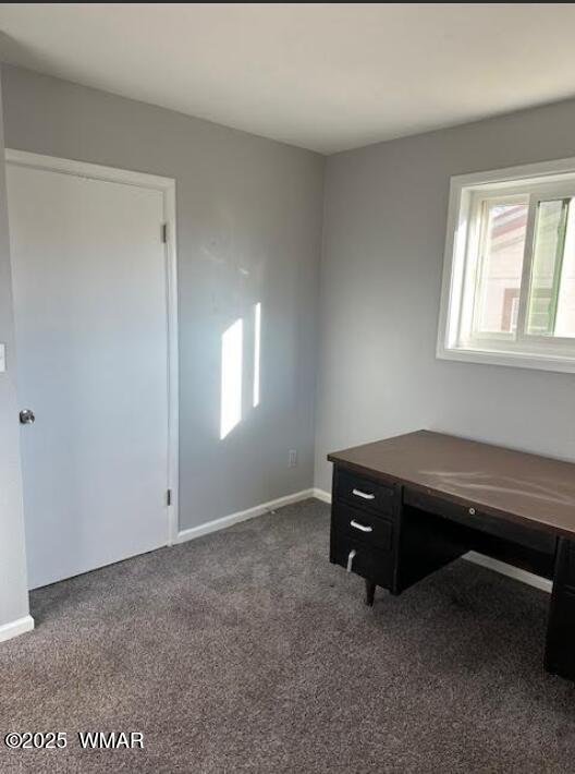 office featuring dark colored carpet and baseboards