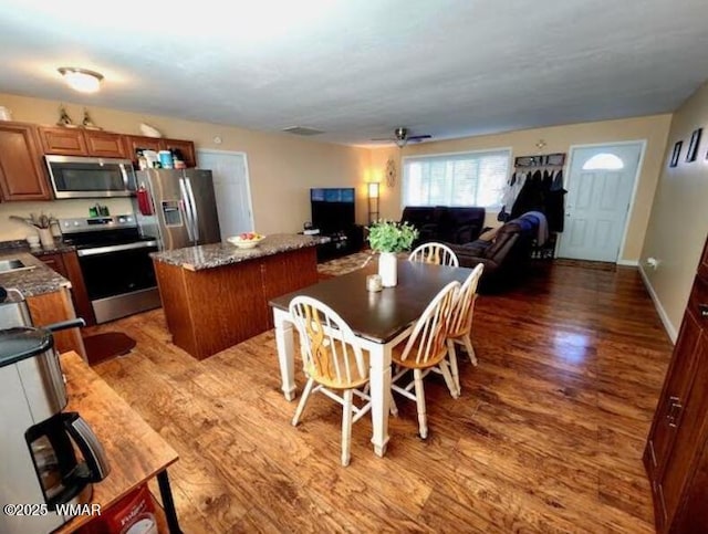 dining room featuring ceiling fan, baseboards, and wood finished floors