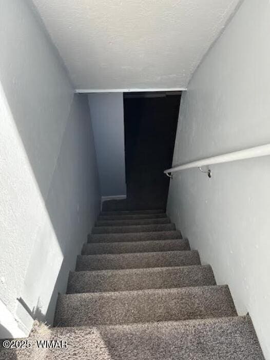 staircase with a textured ceiling