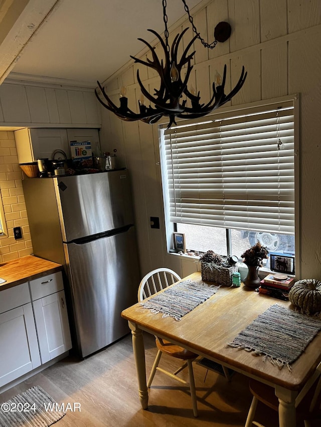 dining area featuring wood walls and light wood-style floors