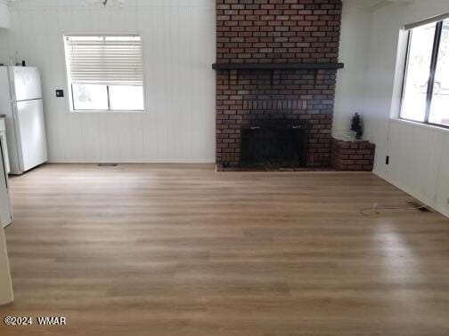 unfurnished living room featuring light wood-type flooring and a fireplace