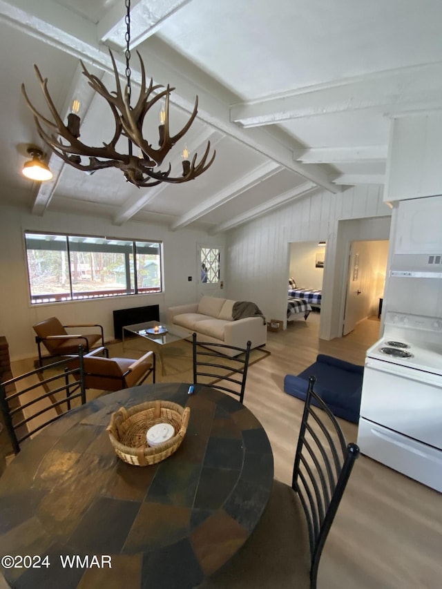 dining space with lofted ceiling with beams, light wood-style floors, and an inviting chandelier