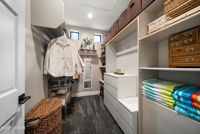 spacious closet featuring dark carpet and attic access