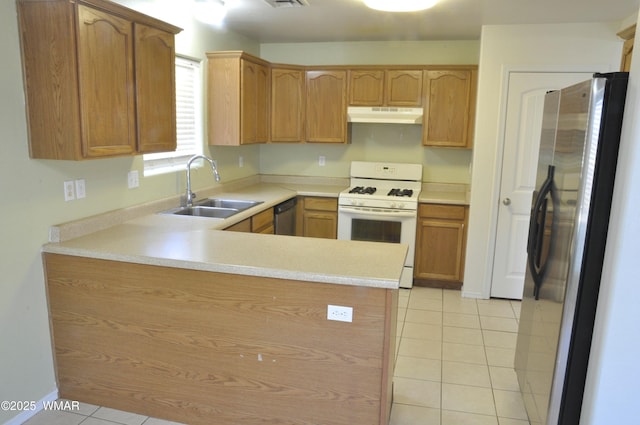 kitchen featuring appliances with stainless steel finishes, light countertops, a sink, and under cabinet range hood