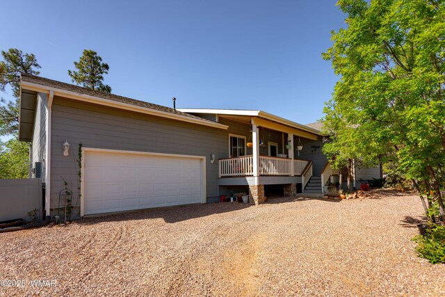 7431 N Gemini Ln, Lakeside, AZ 85929 - view of front of home featuring gravel driveway, a garage, and a porch