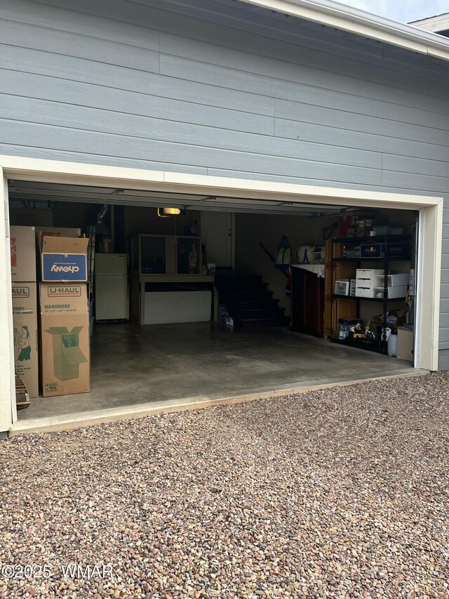 7431 N Gemini Ln, Lakeside, AZ 85929 - garage featuring gravel driveway, freestanding refrigerator, and a garage door opener