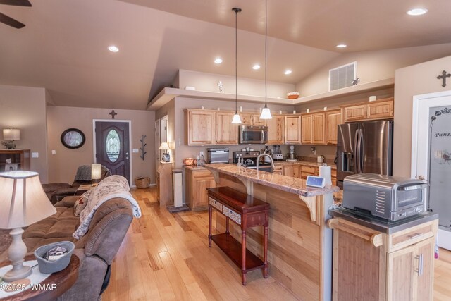 7431 N Gemini Ln, Lakeside, AZ 85929 - kitchen with stainless steel appliances, lofted ceiling, light brown cabinetry, open floor plan, and a kitchen breakfast bar