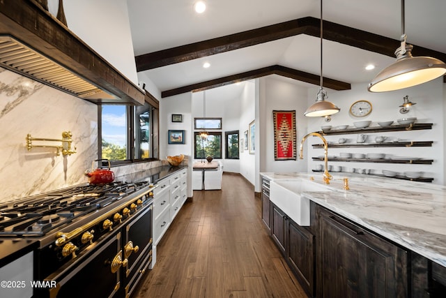 kitchen with lofted ceiling with beams, light stone countertops, stovetop, a sink, and exhaust hood