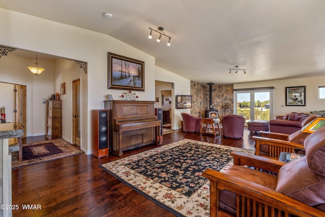 2335 Voyager Cir, Overgaard, AZ 85933 - living area featuring a wood stove, vaulted ceiling, dark wood-style floors, and baseboards