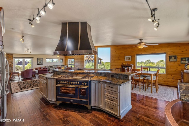 2335 Voyager Cir, Overgaard, AZ 85933 - kitchen featuring track lighting, range hood, open floor plan, a sink, and wooden walls