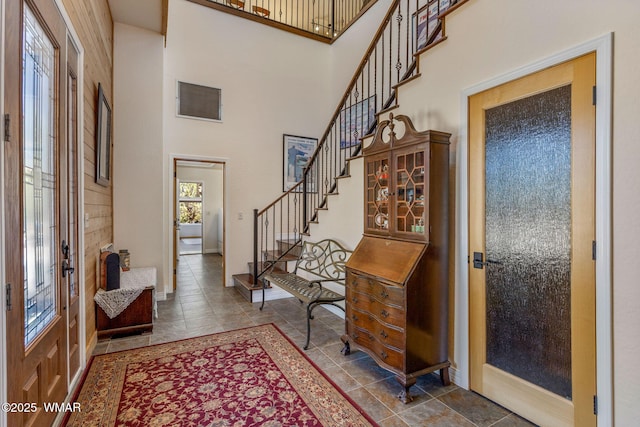2335 Voyager Cir, Overgaard, AZ 85933 - foyer with stairs, a towering ceiling, tile patterned floors, and baseboards