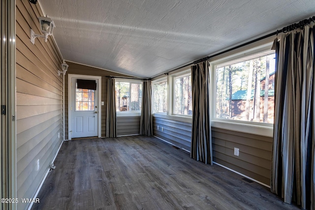 unfurnished sunroom featuring visible vents and vaulted ceiling