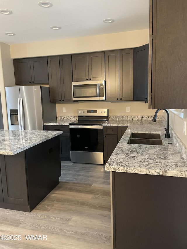 2426 Aspen Run, Pinetop, AZ 85935 - kitchen with recessed lighting, stainless steel appliances, a sink, light stone counters, and light wood finished floors