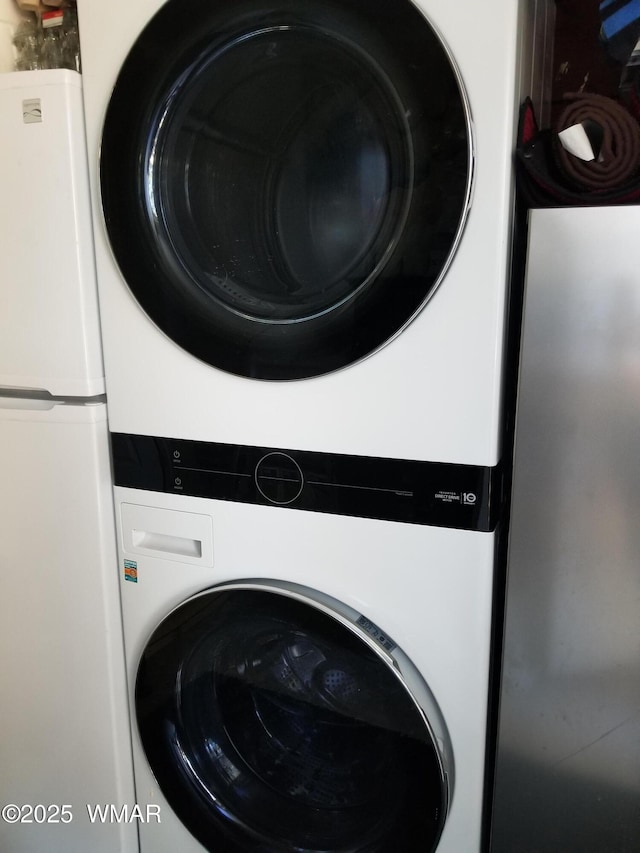 washroom with stacked washer and dryer and laundry area