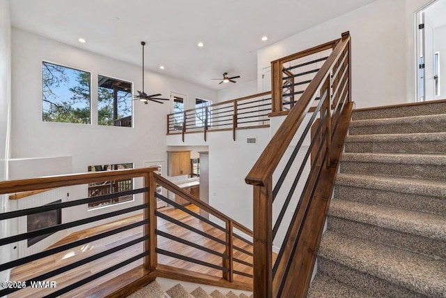 staircase featuring recessed lighting, a ceiling fan, and visible vents