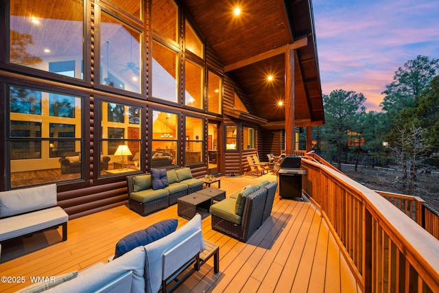 deck at dusk featuring outdoor lounge area and area for grilling