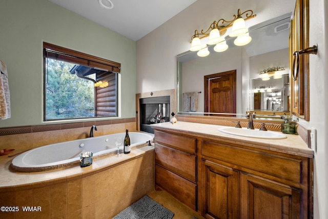 bathroom featuring a fireplace, visible vents, a bath, and vanity