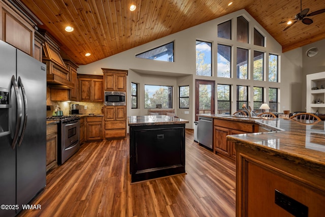 kitchen featuring wooden ceiling, a kitchen island, appliances with stainless steel finishes, and brown cabinets