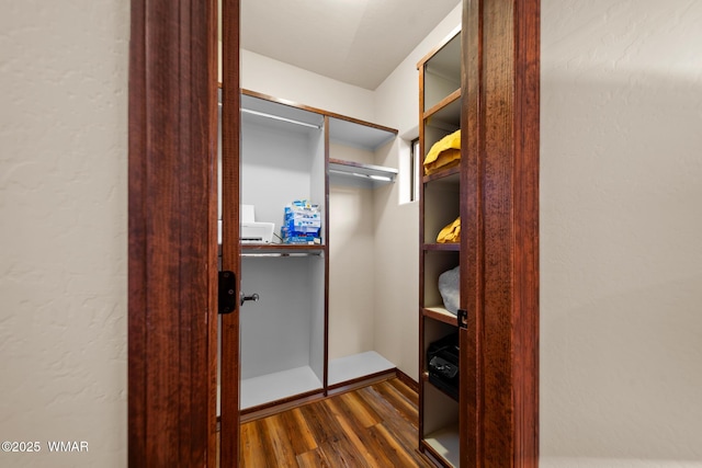 spacious closet with dark wood-style flooring