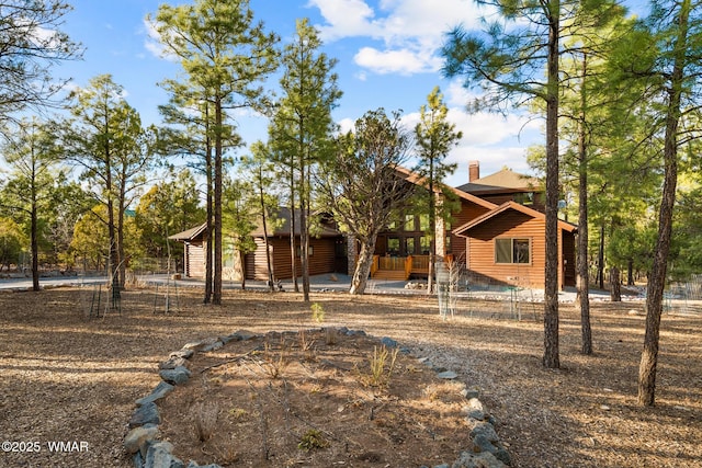 view of front of house with log veneer siding and a chimney