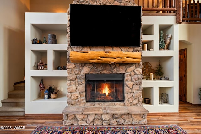 details with built in shelves, a fireplace, and wood finished floors