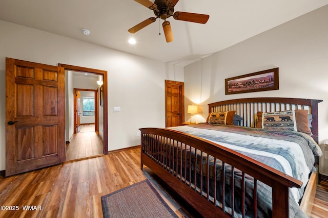 bedroom with wood finished floors, a ceiling fan, and baseboards