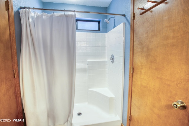 bathroom featuring a shower stall and a textured wall