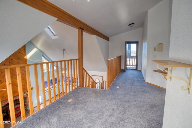 hall featuring carpet floors and lofted ceiling with skylight