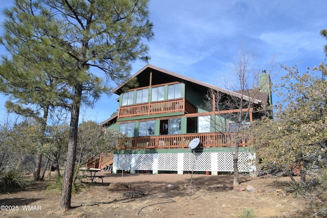 rear view of property with a deck and a chimney