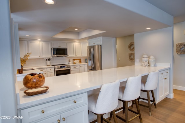 3651 Crown Dancer Dr Unit 8, Pinetop, AZ 85935 - kitchen with light countertops, recessed lighting, light wood finished floors, a peninsula, and appliances with stainless steel finishes