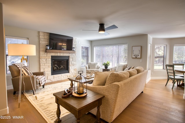 3651 Crown Dancer Dr Unit 8, Pinetop, AZ 85935 - living room with wood finished floors, a healthy amount of sunlight, a ceiling fan, and a stone fireplace