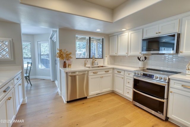 3651 Crown Dancer Dr Unit 8, Pinetop, AZ 85935 - kitchen featuring stainless steel appliances, backsplash, a sink, white cabinets, and light wood-style flooring