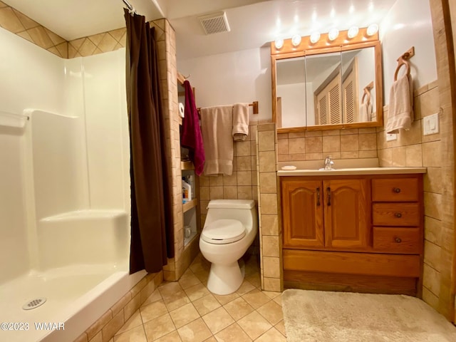 bathroom with visible vents, tile patterned floors, curtained shower, vanity, and tile walls