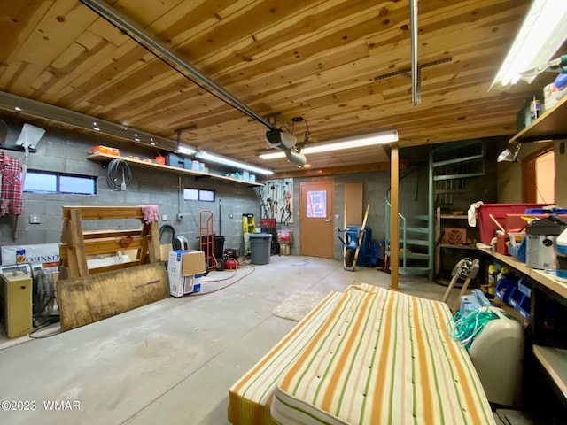 basement with concrete block wall, wood ceiling, and a garage