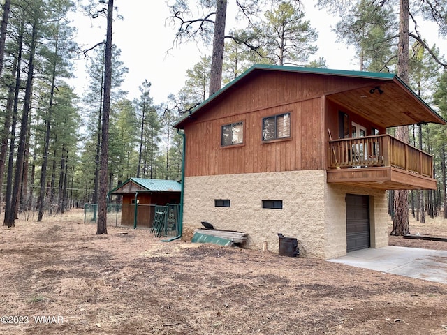 view of property exterior with a garage, concrete driveway, stucco siding, and central AC unit