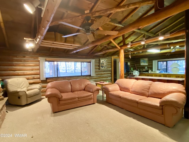 living room featuring ceiling fan, high vaulted ceiling, beamed ceiling, and rustic walls